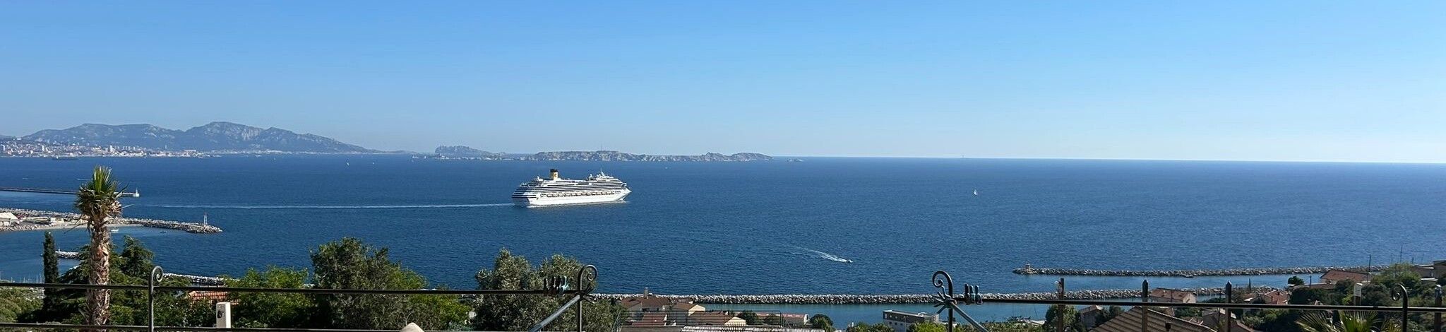 La rade de Marseille depuis la villa : la ville et les collines à gauche, un paquebot, la pleine mer, les digues du port de L'Estaque.